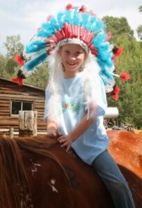 kids on horse in headdress