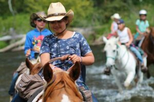 kids crossing stream on horseback