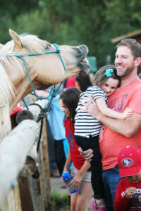 family smiling at horse