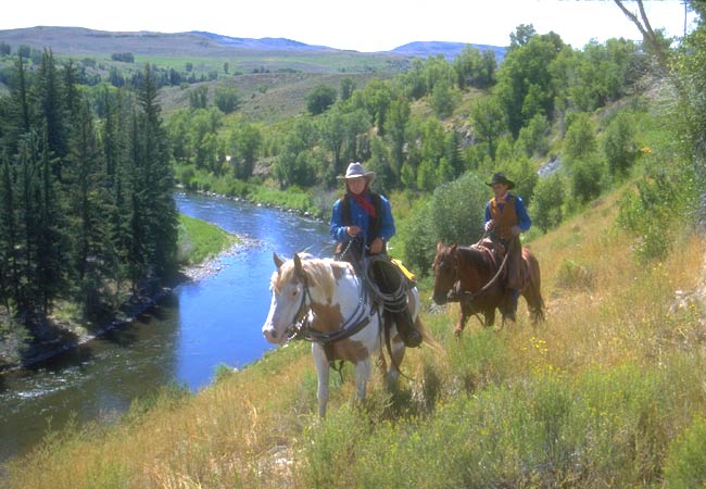 horseback riders above river