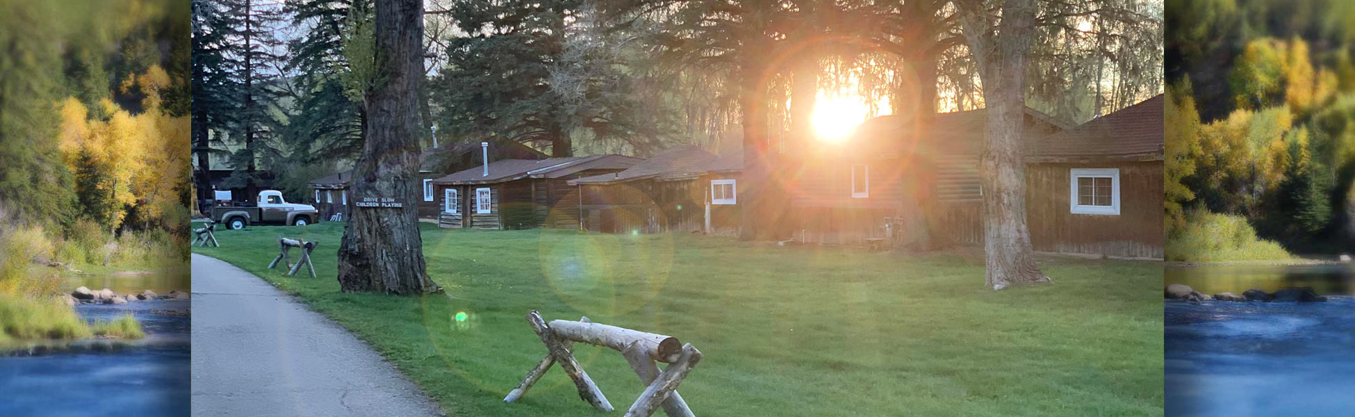 Sun rays through trees over cabins