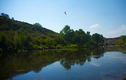 view from river of person on zipline